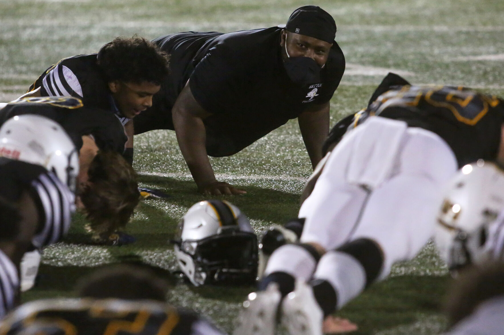 Battle High School head football coach Atiyyah Ellison does push-ups with his team